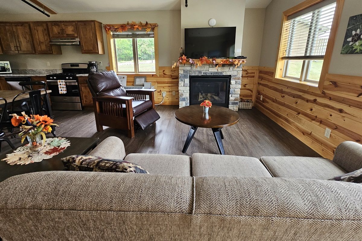 A living room with a fireplace, a sofa, a coffee table, and a television.