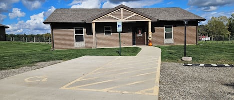 A building with a ramp leading to a door, a parking sign, and a wheelchair-accessible entrance.