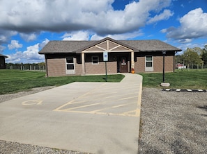 A building with a ramp leading to a door, a parking sign, and a wheelchair-accessible entrance.