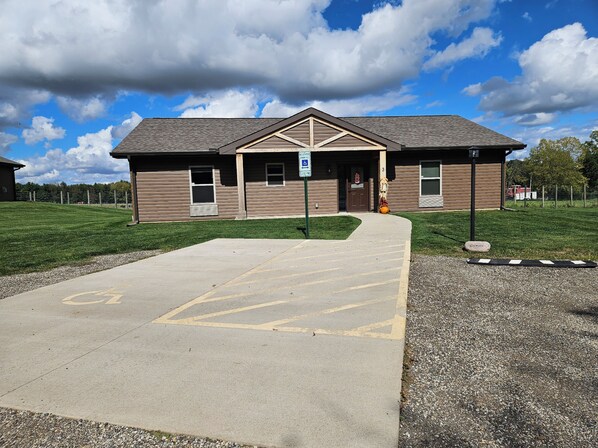 A building with a ramp leading to a door, a parking sign, and a wheelchair-accessible entrance.