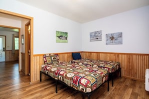 A bedroom with a wooden bed, a wooden headboard, and a small bedside table.