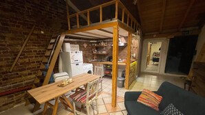 A compact living space with a loft area, kitchen, and seating area.