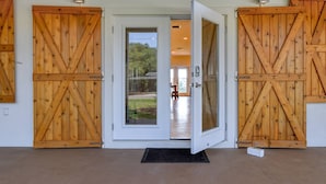 A building entrance with two large wooden doors and a glass door leading to an interior space. - Castaway Cottage (St. Augustine)