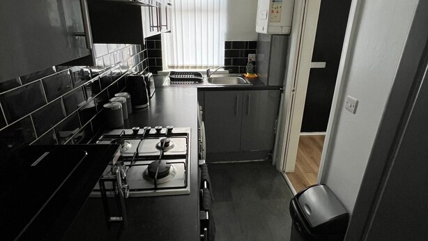 A compact kitchen with a gas stove, a sink, and a small countertop. - City Escape - Charming 2-bed House (Leeds)