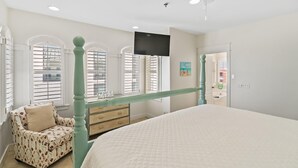 A bedroom with a bed, a dresser, a chair, and a television on the wall. - Endless Sea (Santa Rosa Beach)