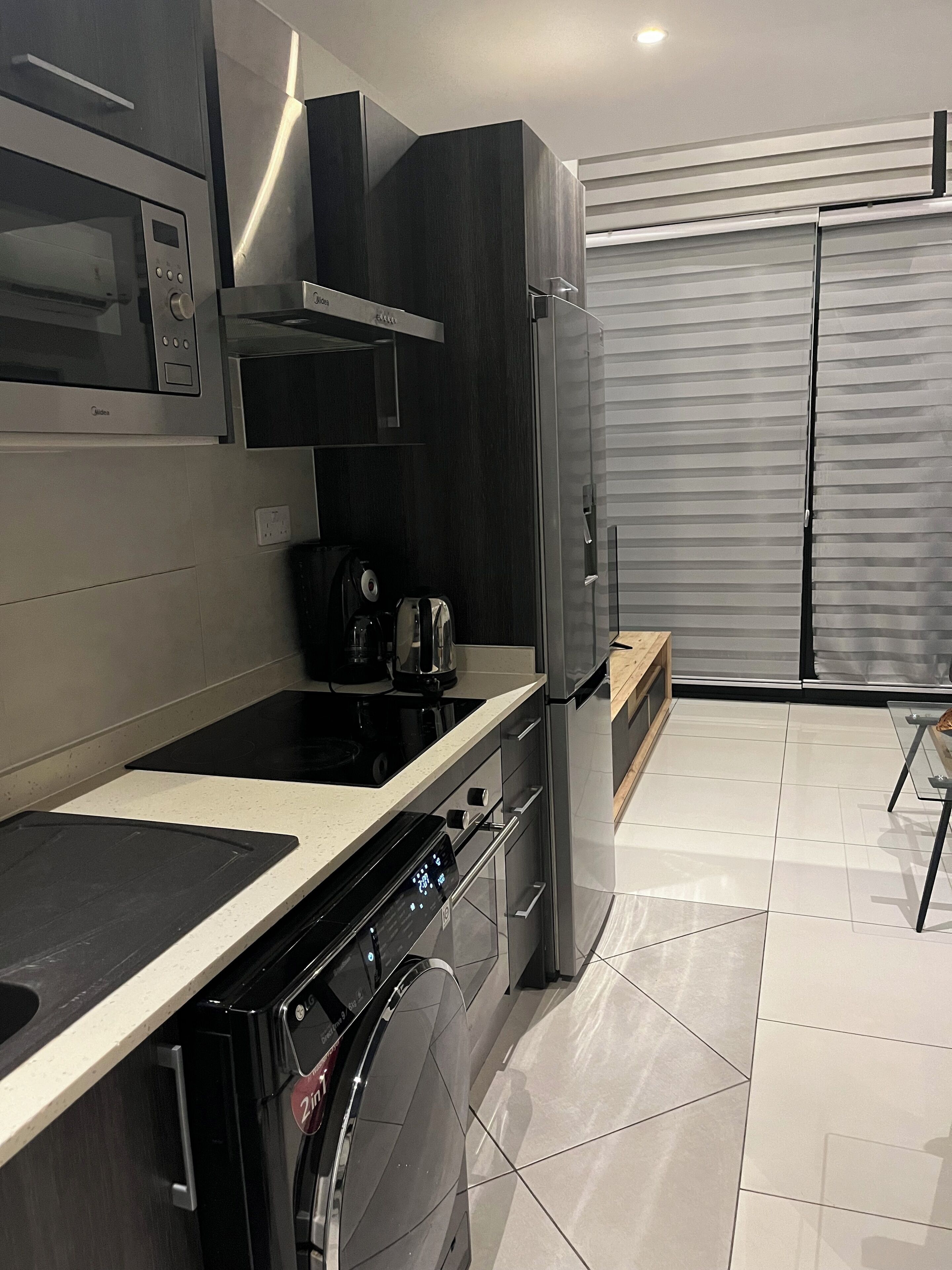 Eine moderne Küche mit Backofen, Mikrowelle und Kaffeemaschine.