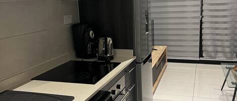 Eine moderne Küche mit Backofen, Mikrowelle und Kaffeemaschine.