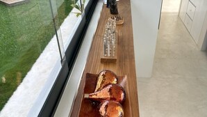 Eine moderne Küche mit Holzarbeitsplatte, Blick zum Garten und einem blauen Sofa.