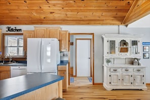 Kitchen area with oven, refrigerator, and wooden cabinetry.