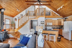 Cozy living space with a loft area featuring a staircase, seating area, and modern kitchen.