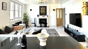A modern living room with a central island, a fireplace, and a television. - 3 Bdm Flat w/ HotTub and RoofTop (Greater London)