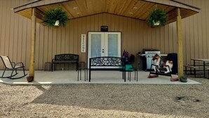 Un bâtiment doté d’un patio couvert, d’une pancarte d’accueil, d’un banc, d’une table et d’une statue de cheval.