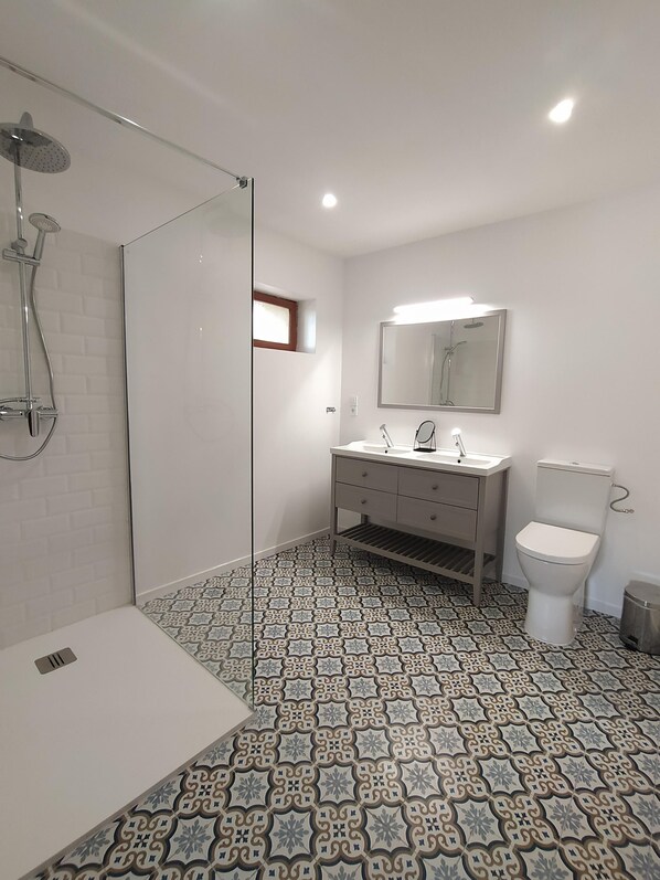 Un baño moderno con ducha, inodoro y lavamanos.