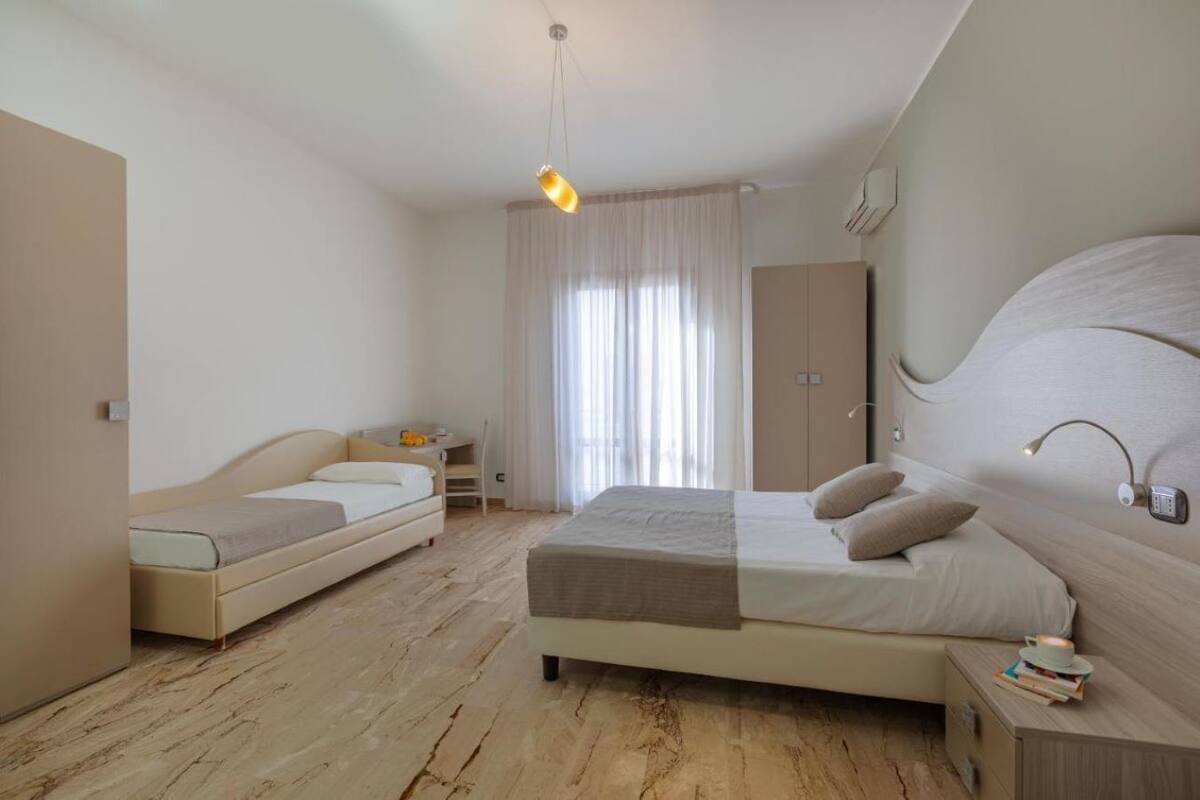 A bedroom with a bed, a desk, and a chair.