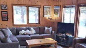A cozy living room with a wooden ceiling, a sofa set, a coffee table, and a television. - Bear Valley Alpine Cabin-3bdrm2bth (Bear Valley)