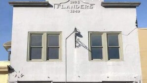 Un edificio de dos pisos con un letrero que dice "FLANDERS 1928".