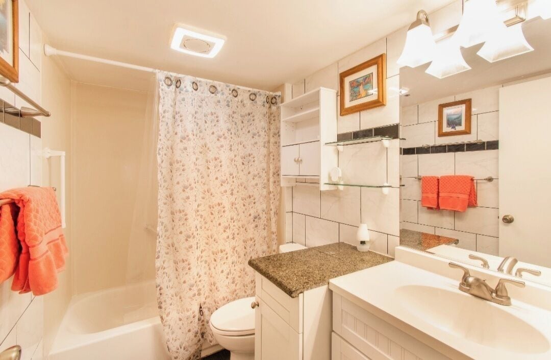 A bathroom with a shower, toilet, and sink.