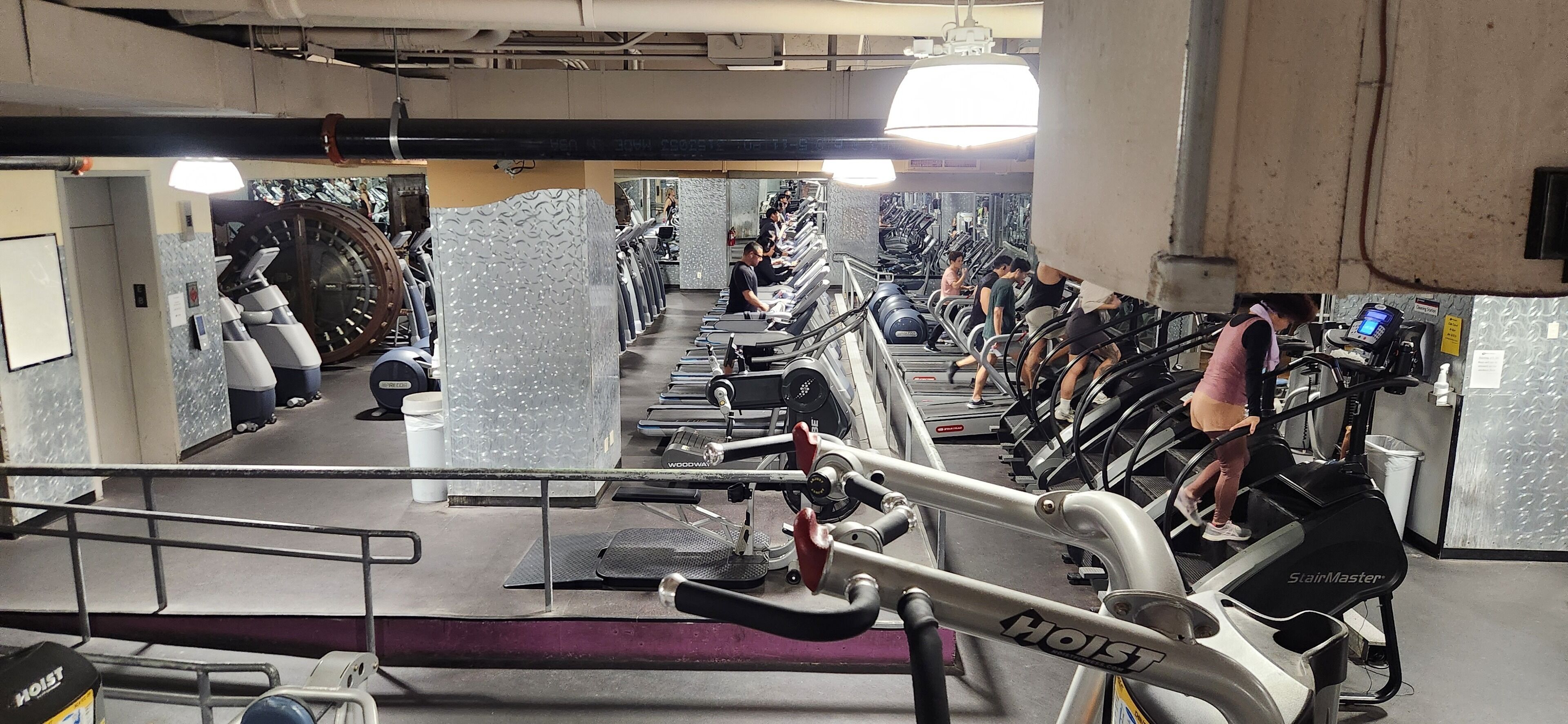 Un gimnasio con cintas de correr, bicicletas estáticas y equipamiento de ejercicio.