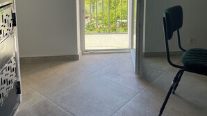 A room with a balcony door, a chair, and a metal cabinet. - Maison de Caractère (Peyroules)