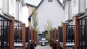 A corridor leading to a building with a gabled roof and a small window. - Summit Rails | 3BR Loft | Unique Canmore Character | Walk to Everything | Sleeps 6 (Canmore)
