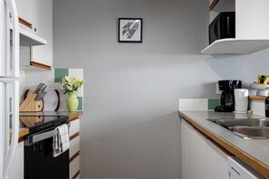 Una cocina moderna con microondas, cafetera y un jarrón con flores.