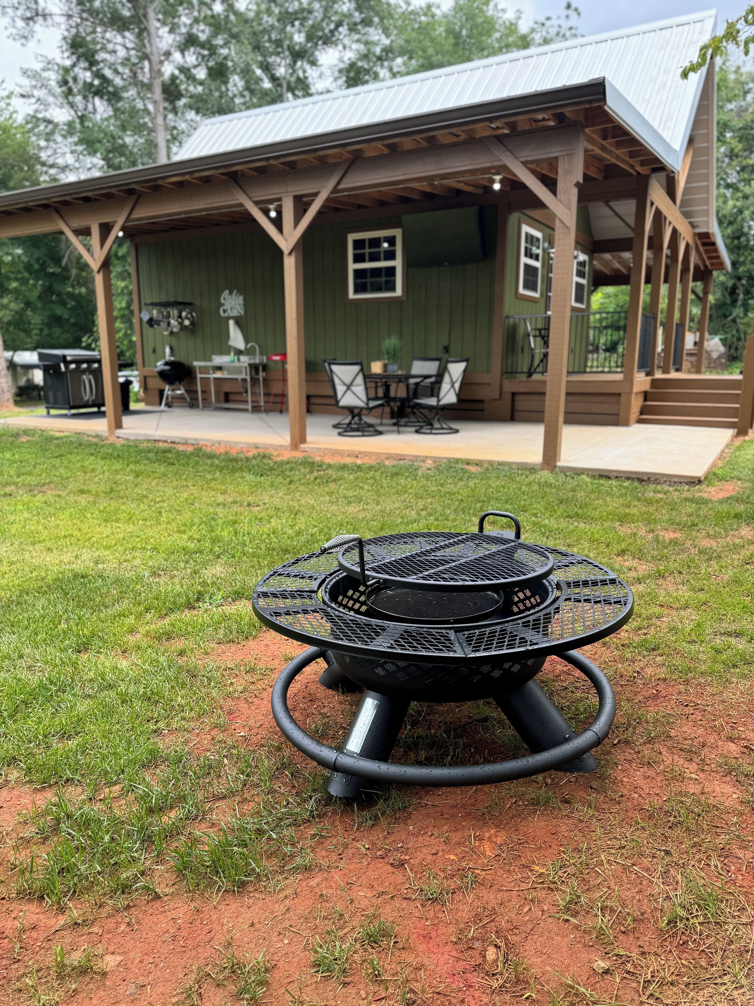 A covered outdoor patio with a grill and dining area.
