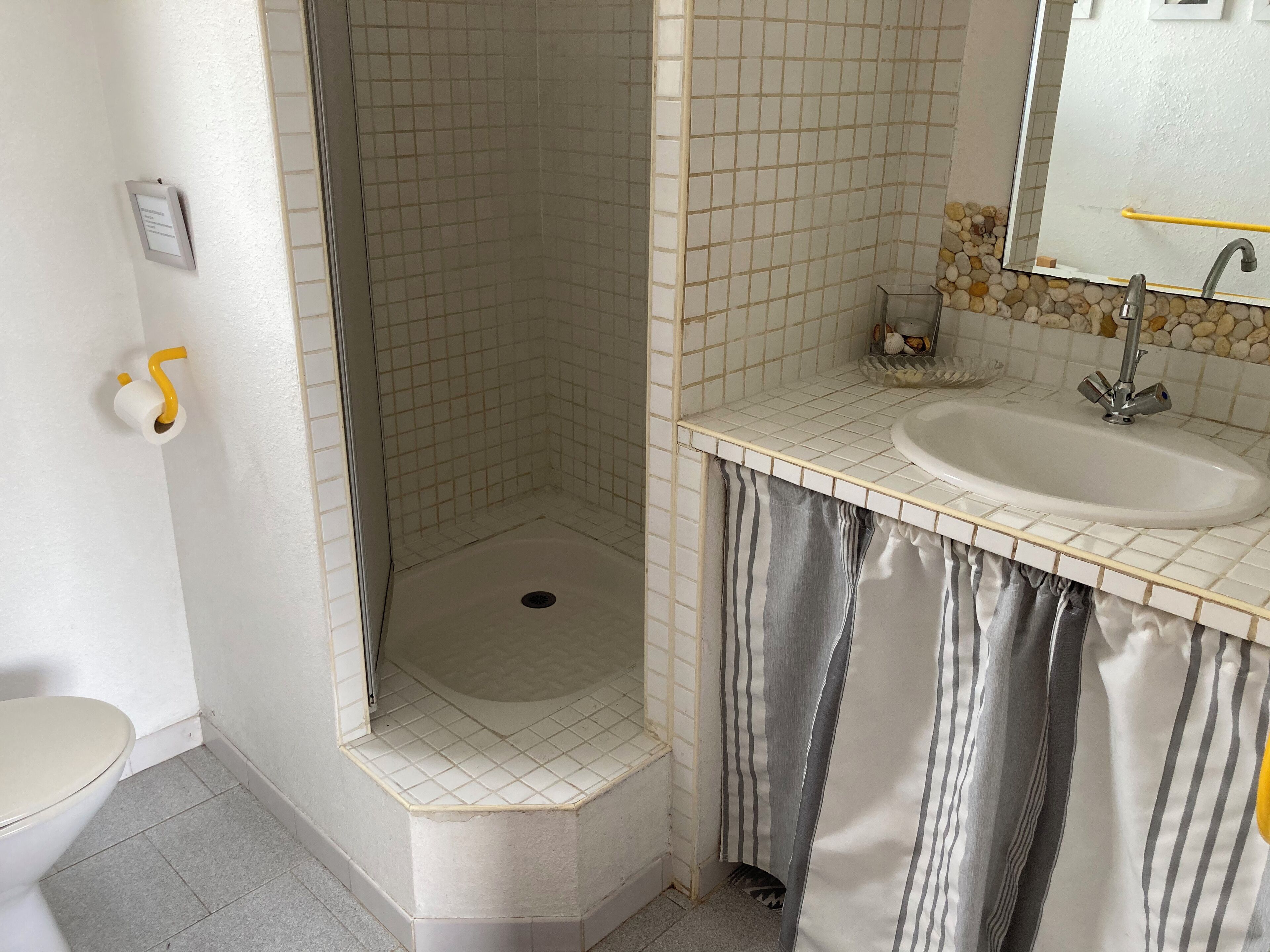 Ein Badezimmer mit Dusche, Toilette und Waschbecken.