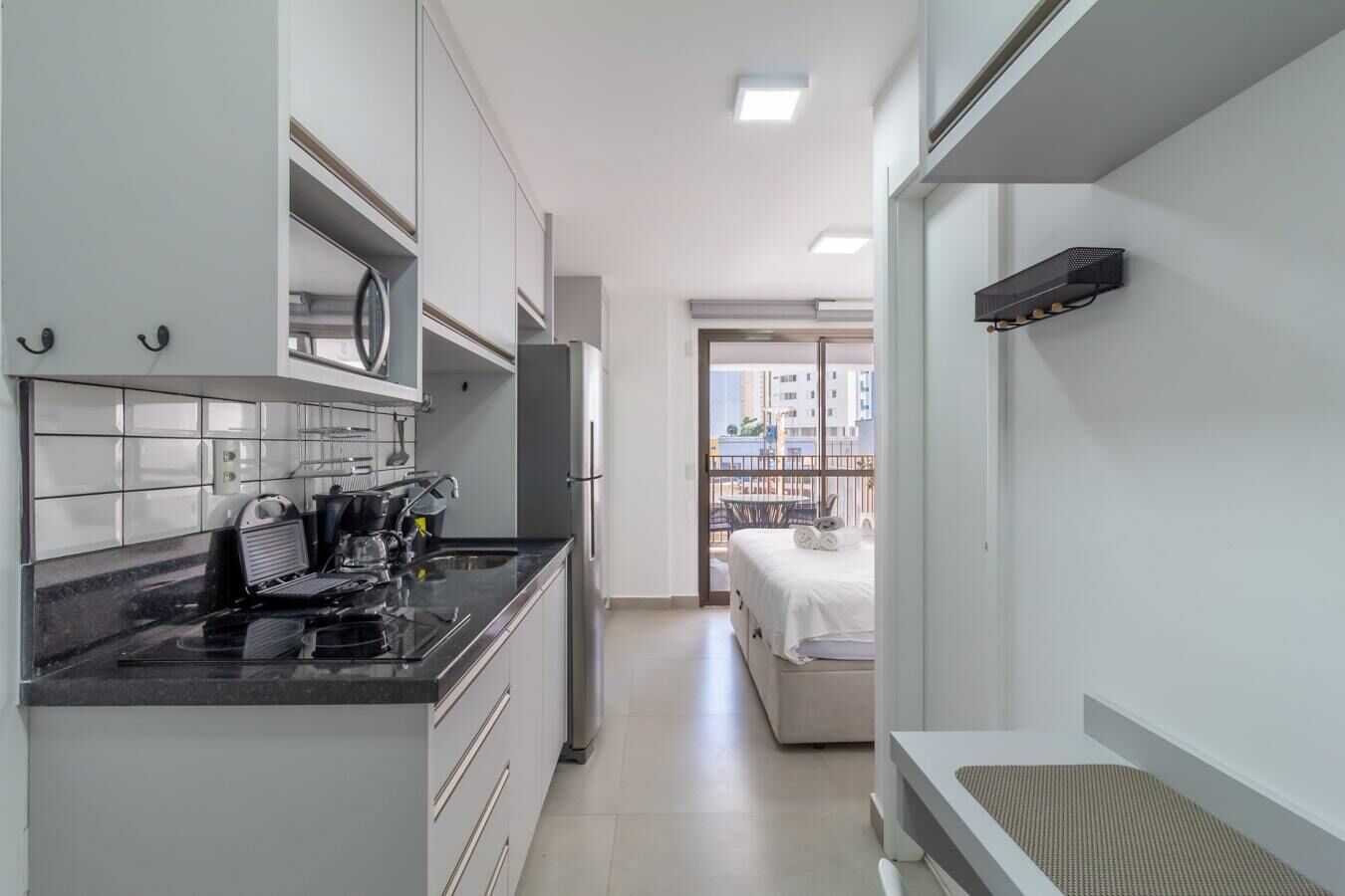 Une cuisine compacte dotée d’appareils électroménagers modernes, un coin repas et un balcon avec vue.