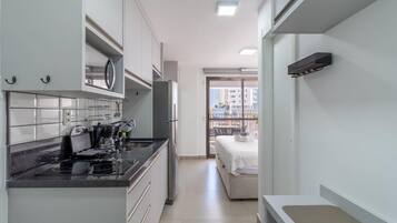 Une cuisine compacte dotée d’appareils électroménagers modernes, un coin repas et un balcon avec vue.