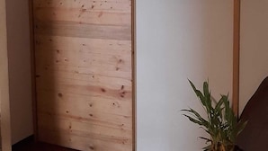 A wooden sliding door with a plant beside it. - Tekla Dorms (Santa Tecla)