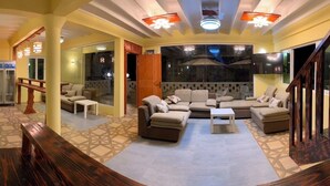 A spacious living area with a large sofa set, a coffee table, and a wooden bench. - Luna lodge  (Olhuvelifushi)