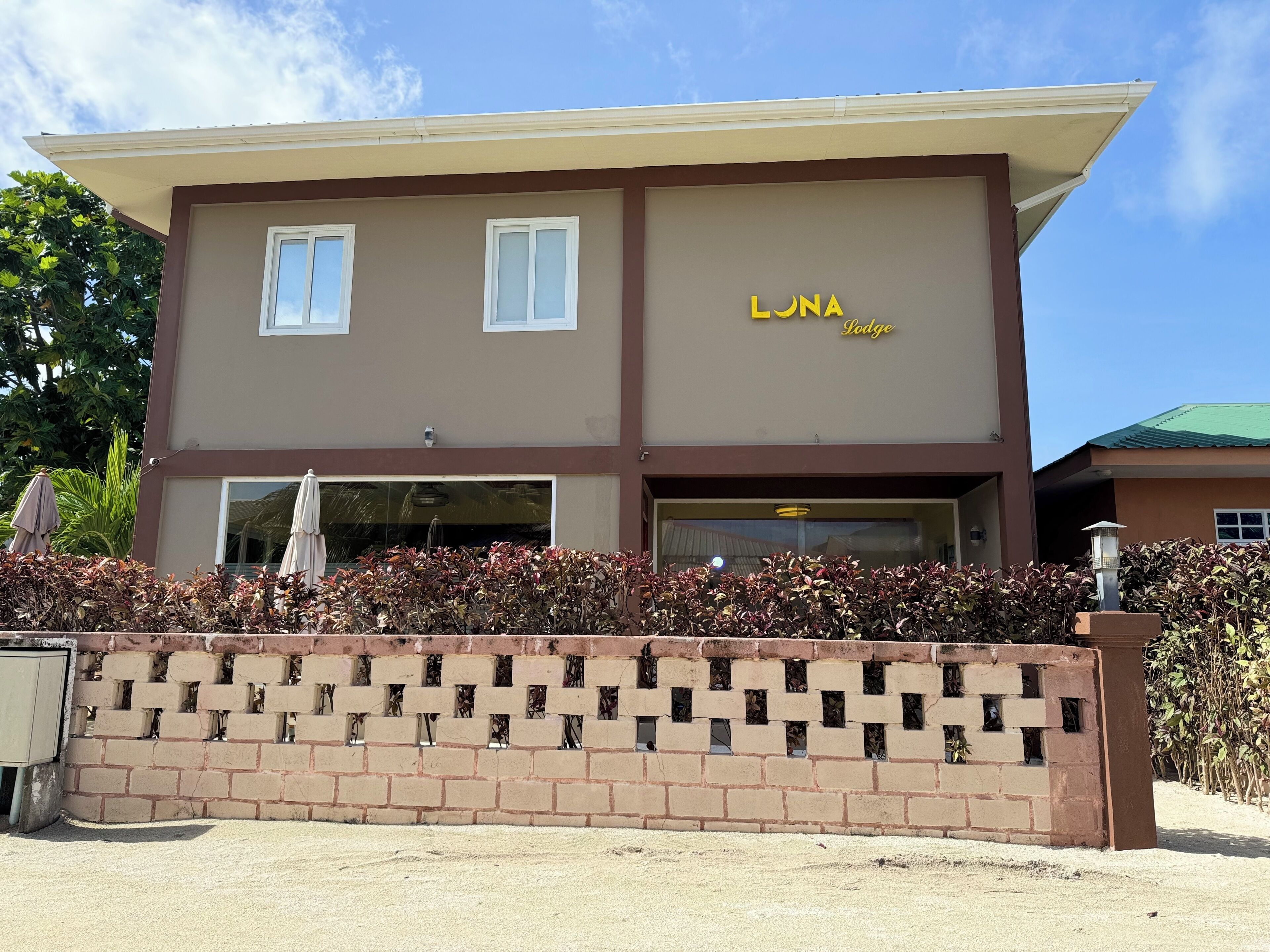 Un edificio de dos pisos con el letrero "LONA Lodge" en la fachada.