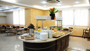 A buffet area with various food items, a coffee machine, and a plant on a shelf. - Flat confortável próximo ao metrô (São Paulo)