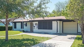 A single-story house with a garage, a front porch, and a lawn. - ALAMO CITY HOMESTYLE BEAUTY GREAT CENTRAL LOCATION, KIDDOS, & FURRY PET FRIENDLY (San Antonio)