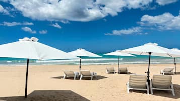 Playa en los alrededores, playa de arena blanca, camastros y sombrillas