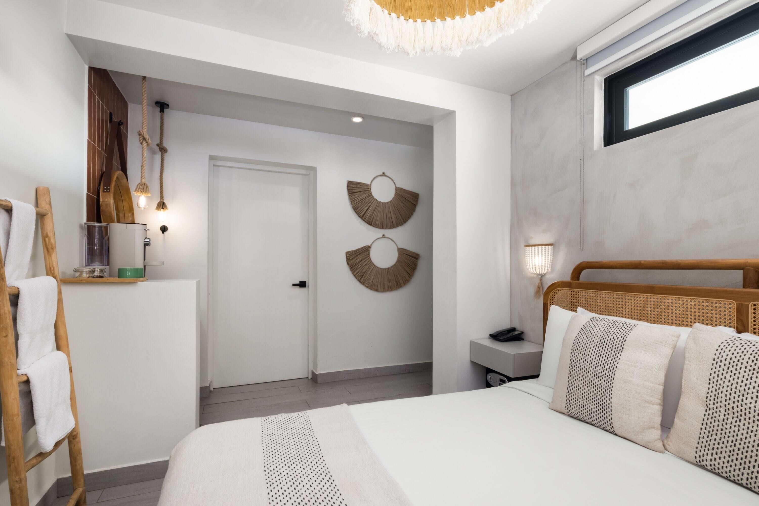 Un dormitorio con cama, cabecera de madera, mesita de noche, lámpara y un adorno en la pared.