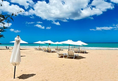 Una playa cerca, arena blanca, sillas reclinables de playa, sombrillas. Bali Hotel Adults Only Isla Verde, a Trademark by Wyndham