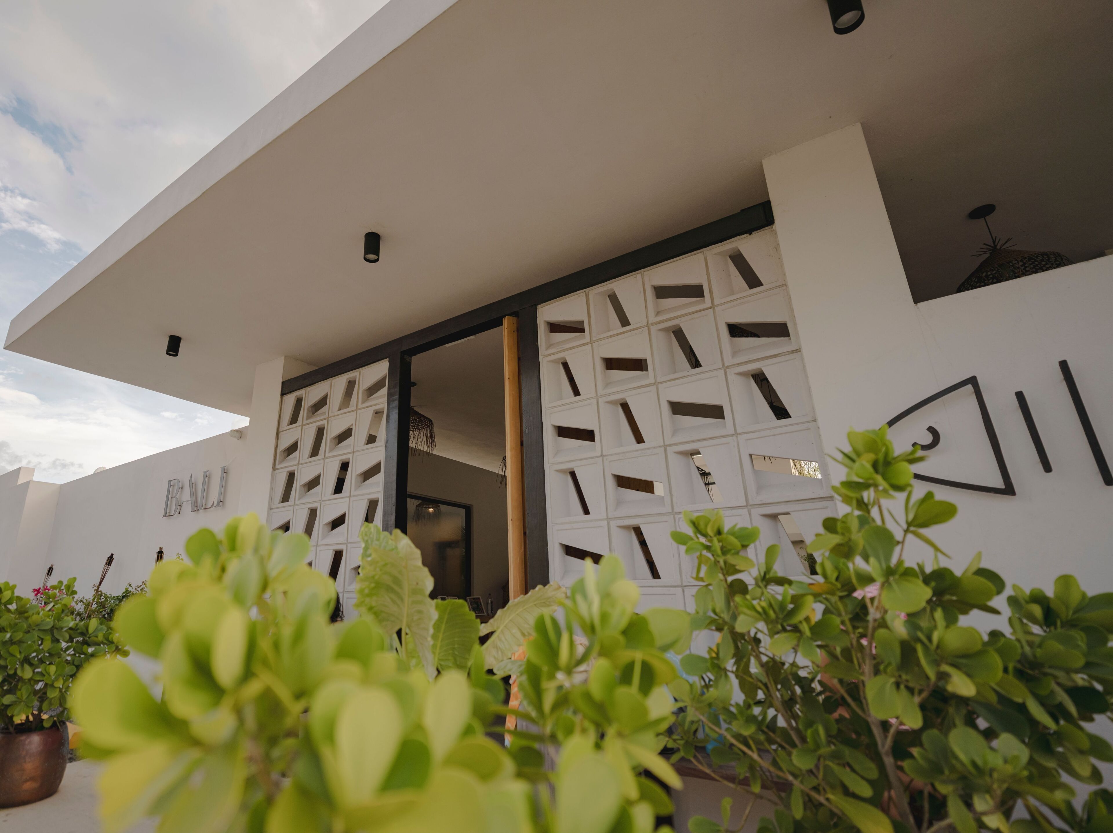 Um edifício moderno com fachada branca e padrões geométricos nas janelas.
