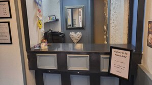 A reception desk with a sign reading "Welcome to the Heron Hotel." - Henson Hotel (Blackpool)