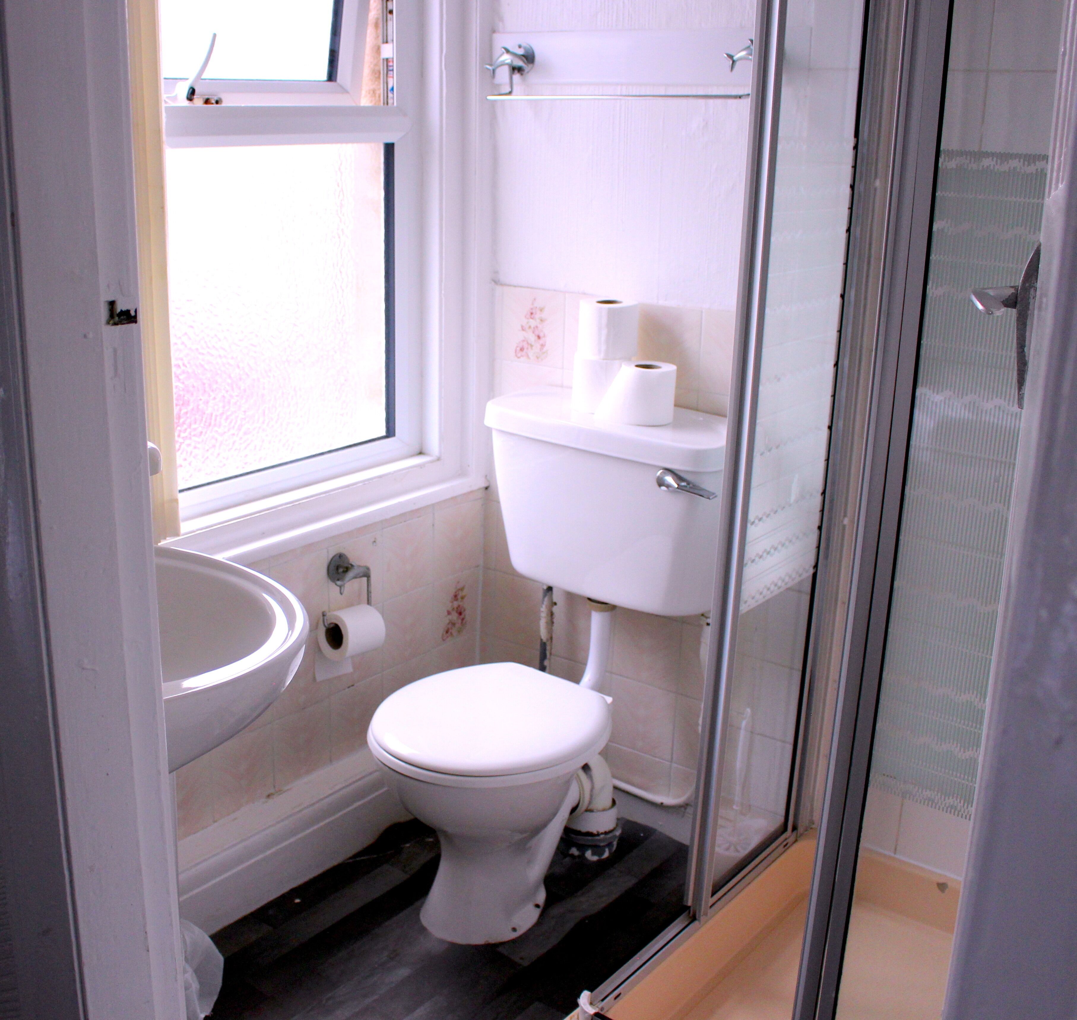 A bathroom with a toilet, sink, and shower.