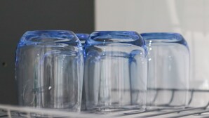 Une rangée de bouteilles en verre transparent sur une étagère.