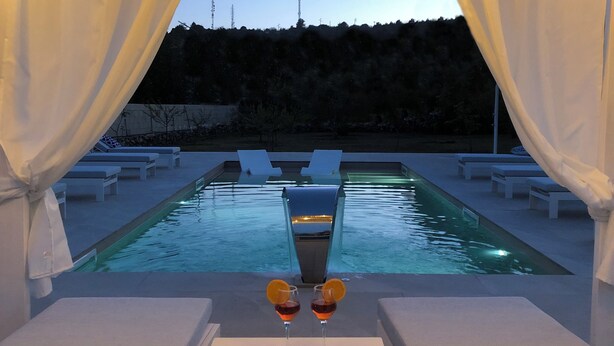 A poolside area with lounge chairs, a table with drinks, and a view of the pool. -  Beautiful villa with pool in Specchia (Specchia)