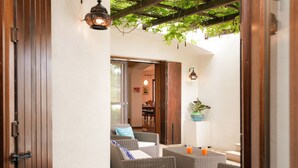 An open patio area with wicker furniture, a dining table, and a potted plant. -  Beautiful villa with pool in Specchia (Specchia)