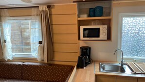 A compact kitchenette with a microwave, coffee maker, and sink. - Mobil-home au Camping 4 Étoiles Familial Les Sables D'or (Agde)
