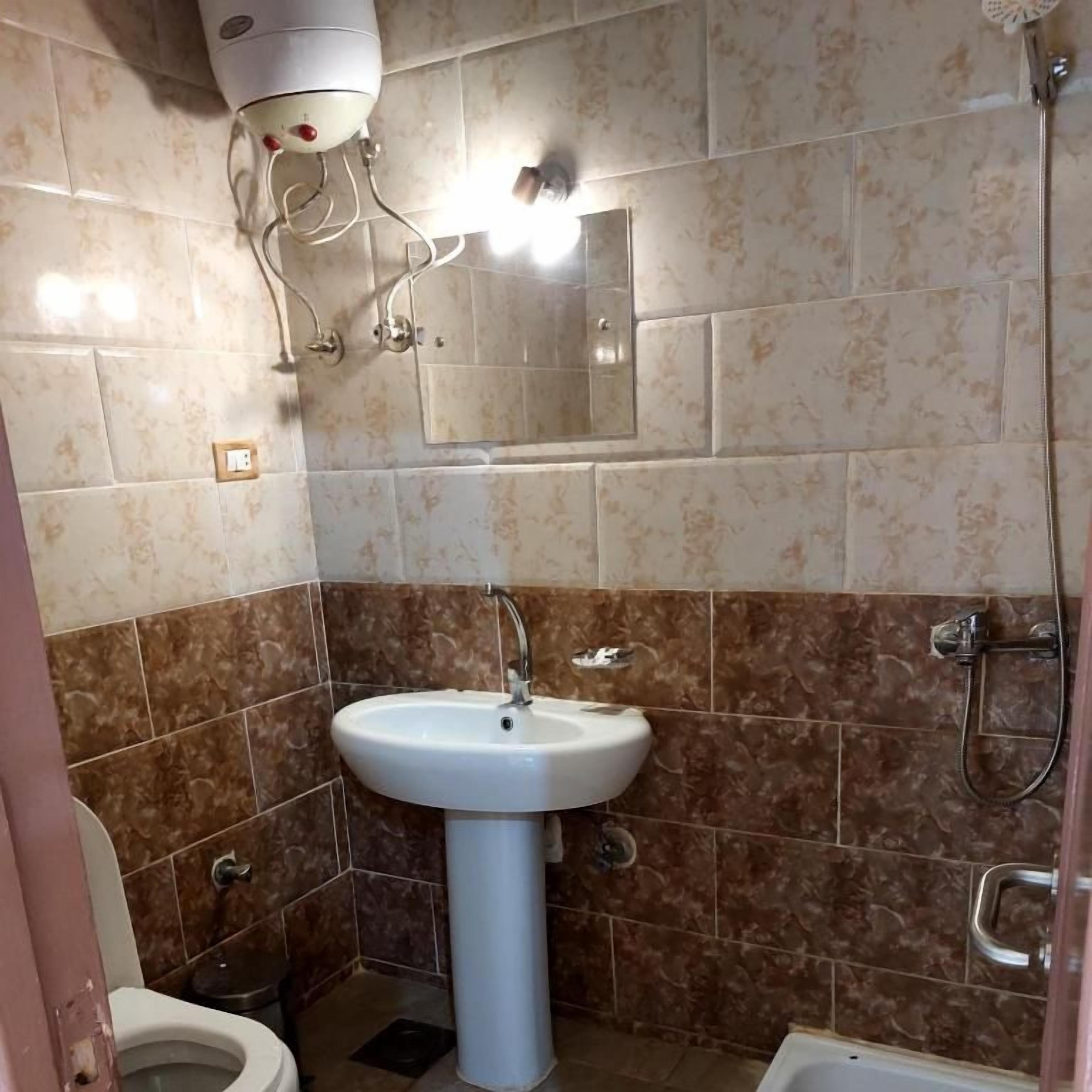 A bathroom with a white sink, a toilet, and a shower area.