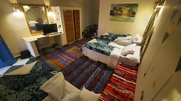 A bedroom with a bed, a desk with a computer, a chair, and a staircase. - Hllol Hotel Abu Simbel (Abu Simbel)