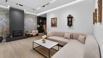 A modern living room with a fireplace, a sofa, a coffee table, and a bookshelf.