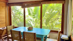 Una habitación con un ventanal grande, una mesa y cuatro sillas.