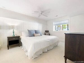A bedroom with a bed, nightstand, dresser, and a ceiling fan. - Newly renovated beauty on main lake with sunrise to sunset panoramic views! (Henrico)