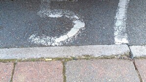 A road marking with the number '57' painted on the asphalt.
